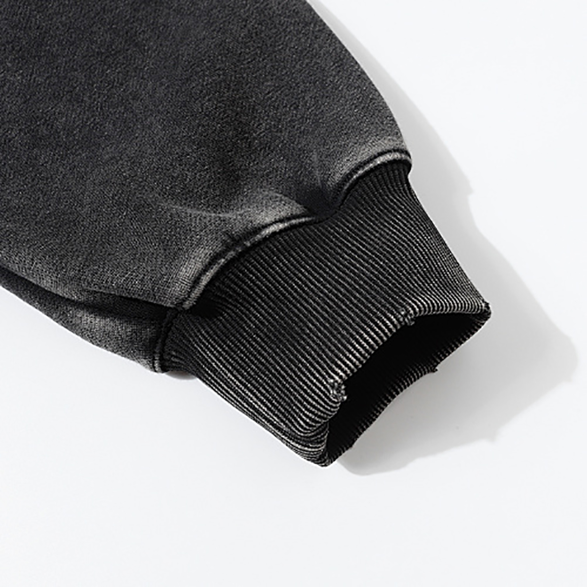 Close-up of men's black heavyweight hoodie ribbed cuff, vintage streetwear