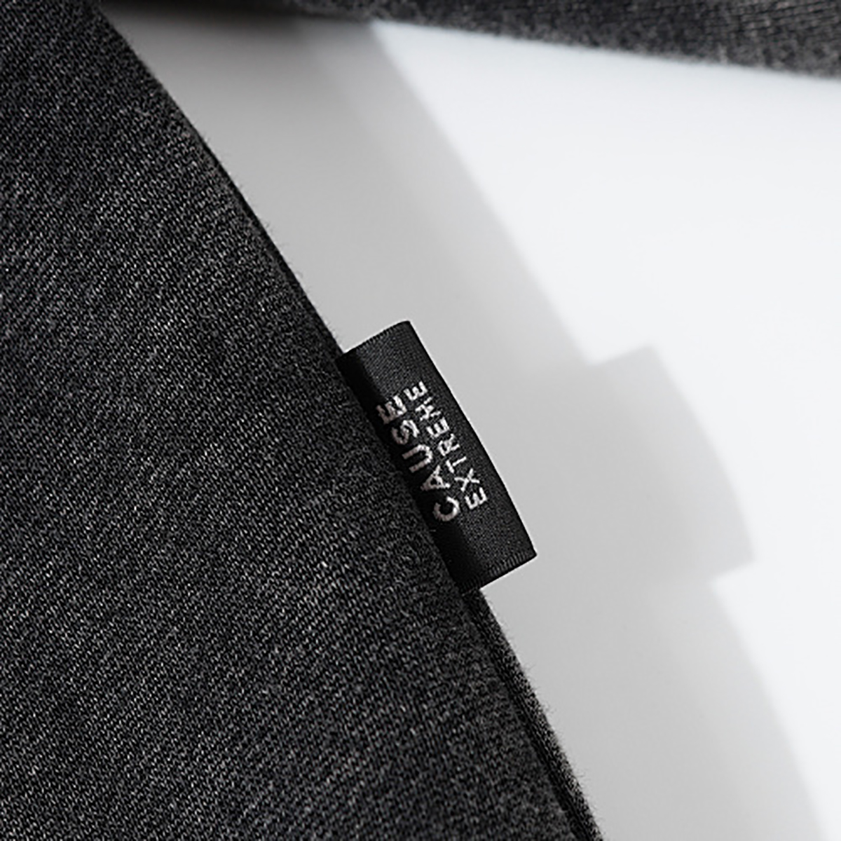 Close-up of men's black heavyweight hoodie side label, vintage streetwear