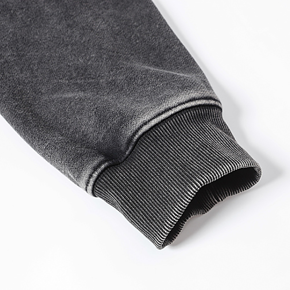 Close-up of men's black heavyweight double-zip hooded fleece zip-up jacket, showing ribbed cuff detail