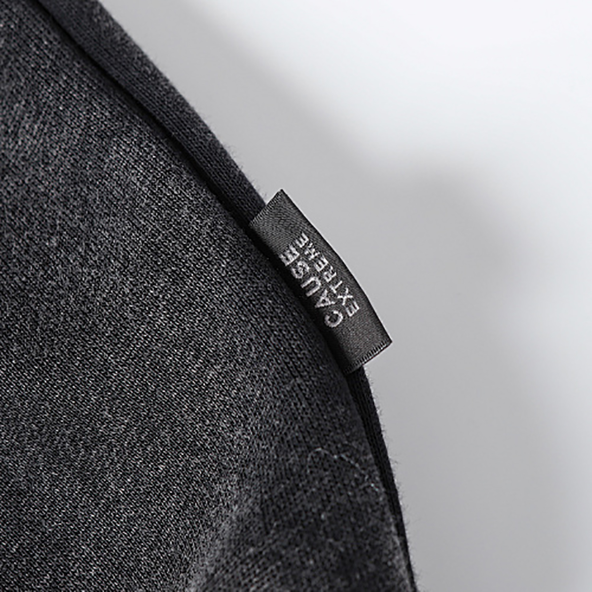 Close-up of men's black heavyweight double-zip hooded fleece zip-up jacket, showing outer brand label detail