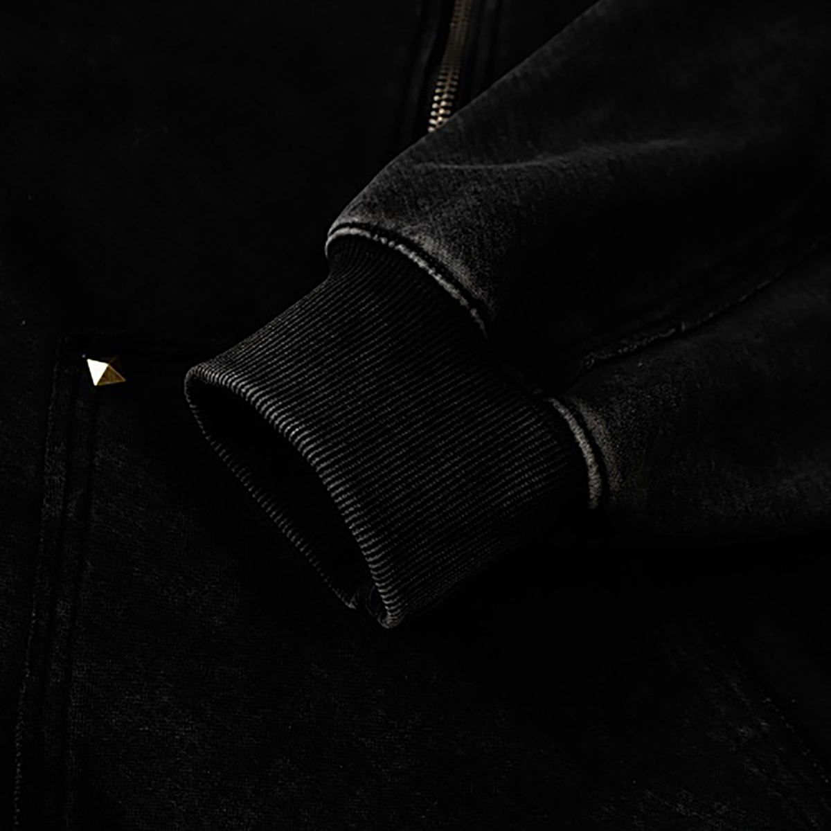 Close-up of cuff details on black high street spray-painted distressed zip-up hoodie