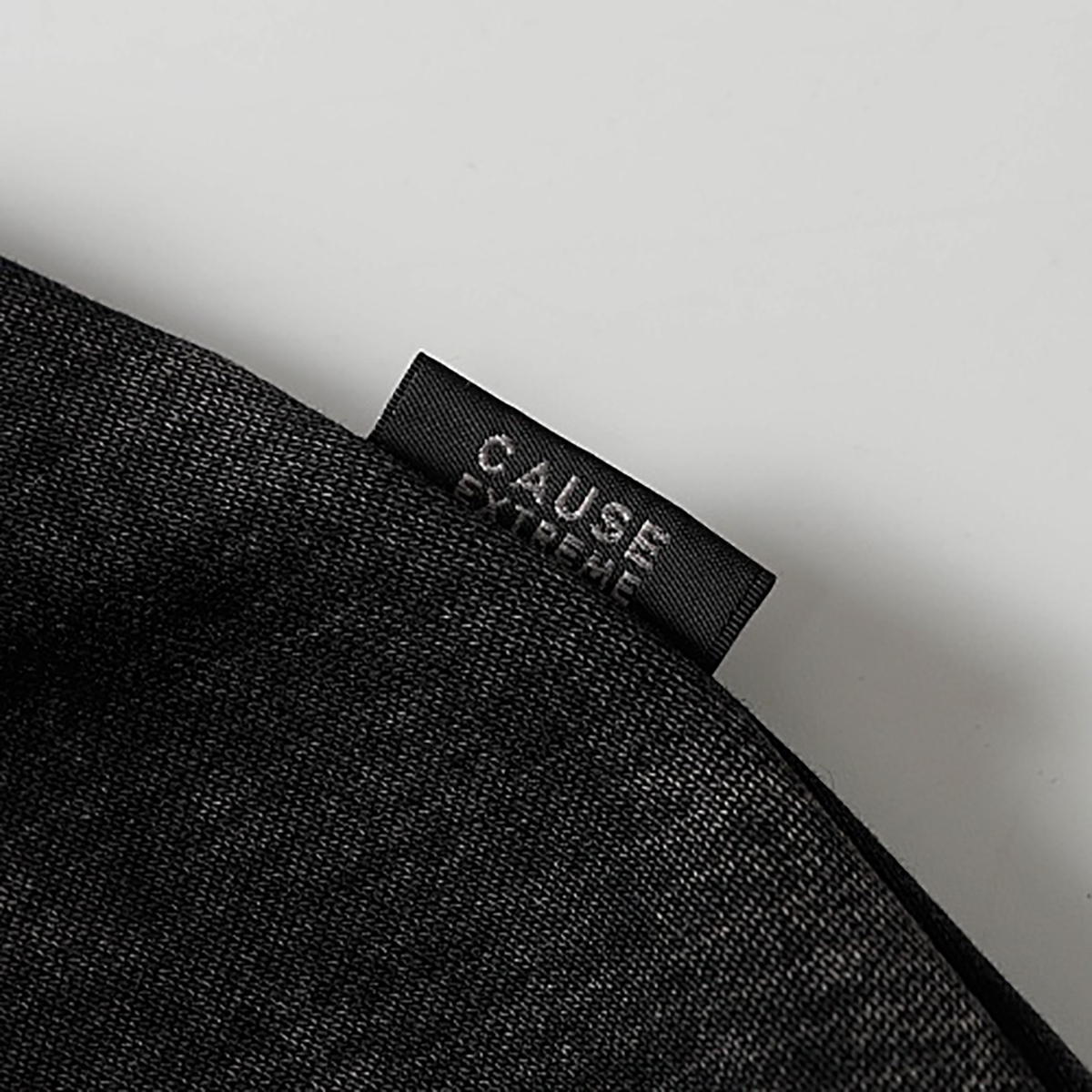 Close-up of brand label detail on black high street spray-painted distressed zip-up hoodie