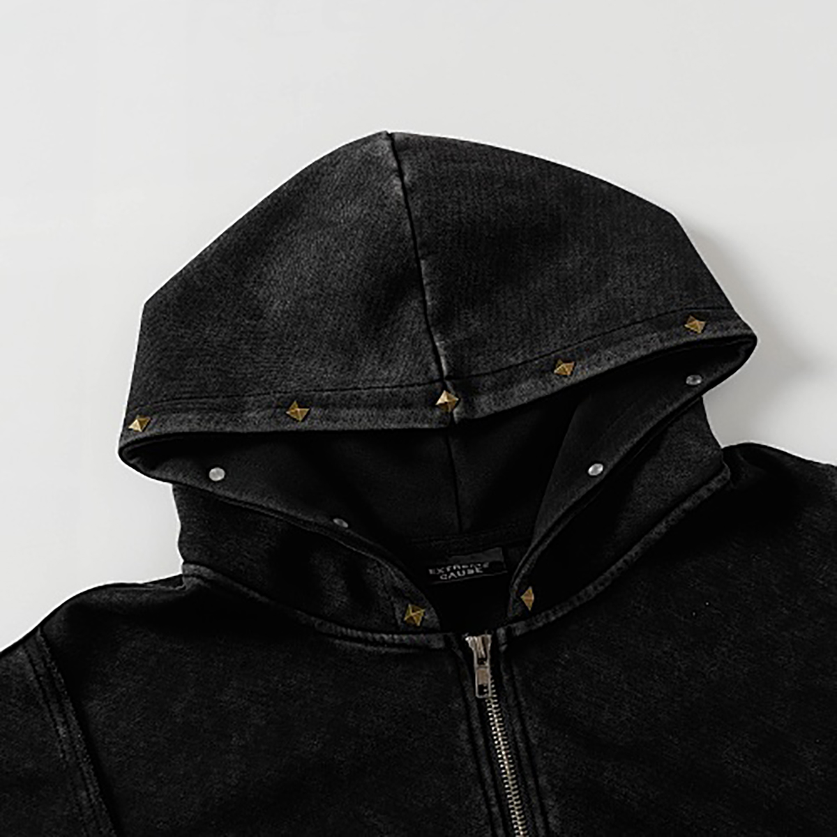 Close-up of hood details on black high street spray-painted distressed zip-up hoodie