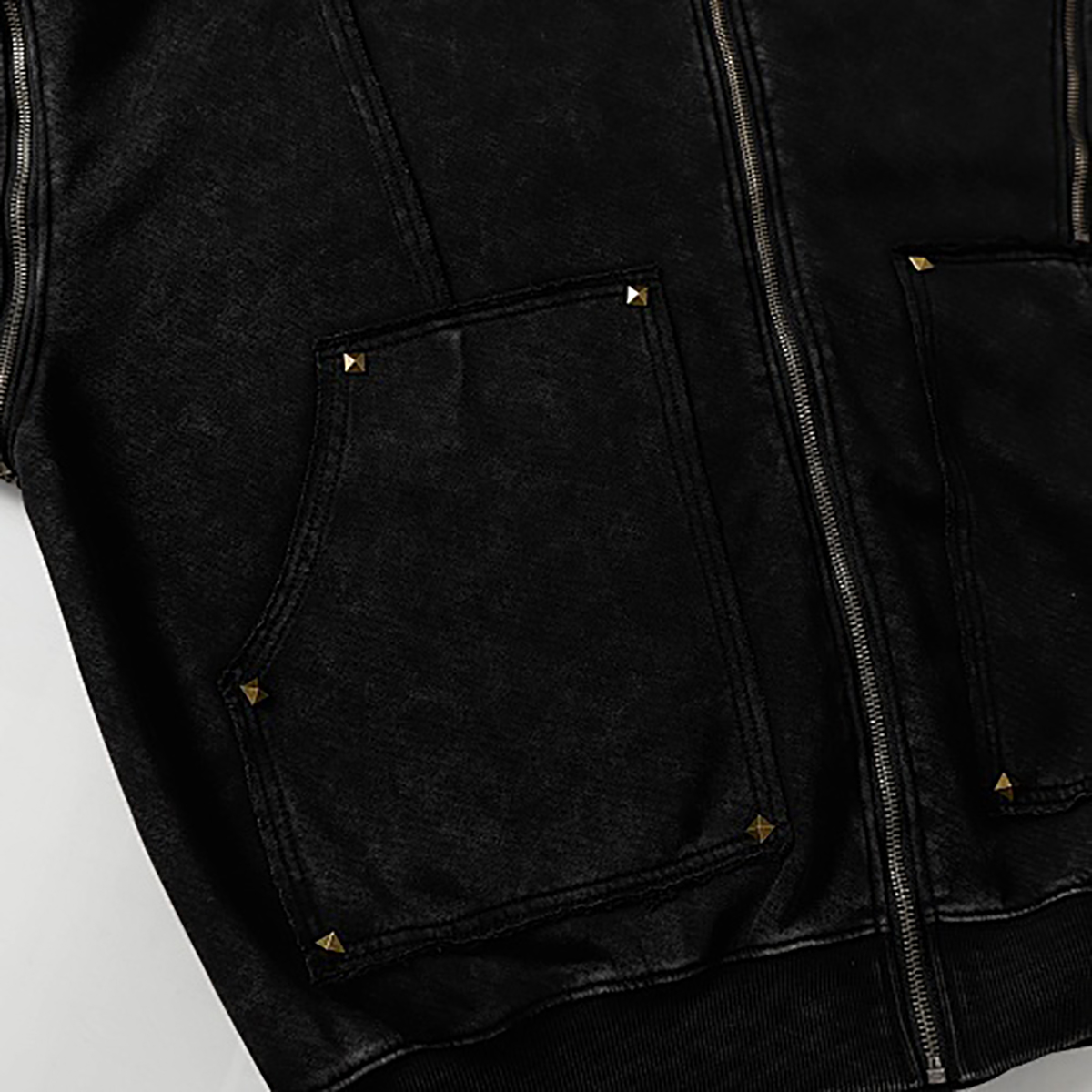 Close-up of pocket details on black high street spray-painted distressed zip-up hoodie