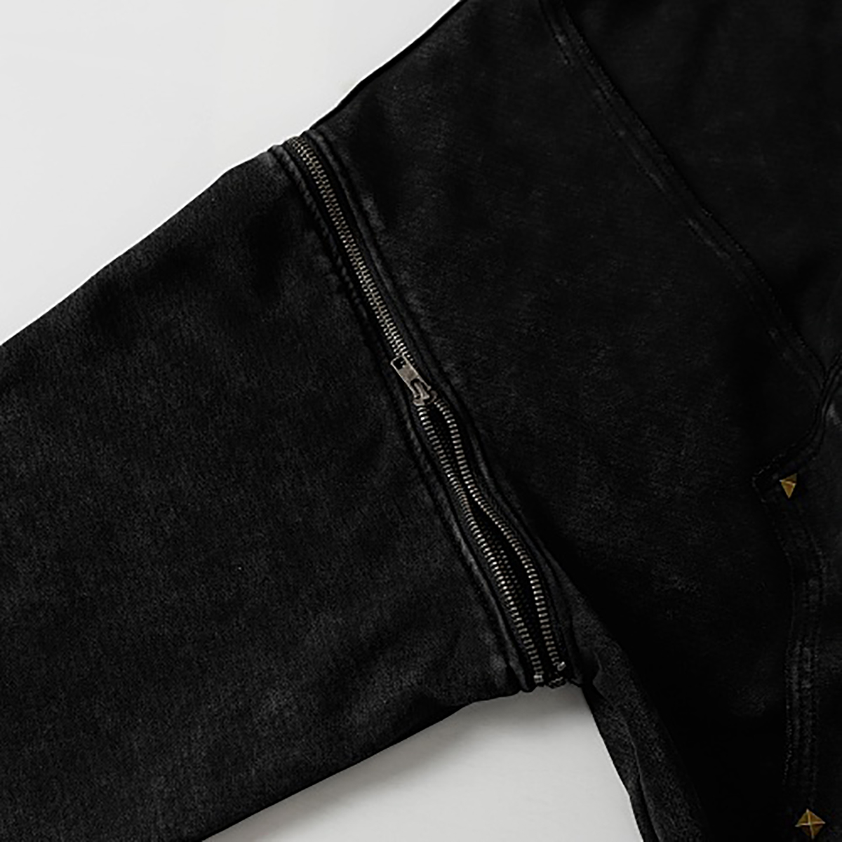 Close-up of sleeve and zipper details on black high street spray-painted distressed zip-up hoodie
