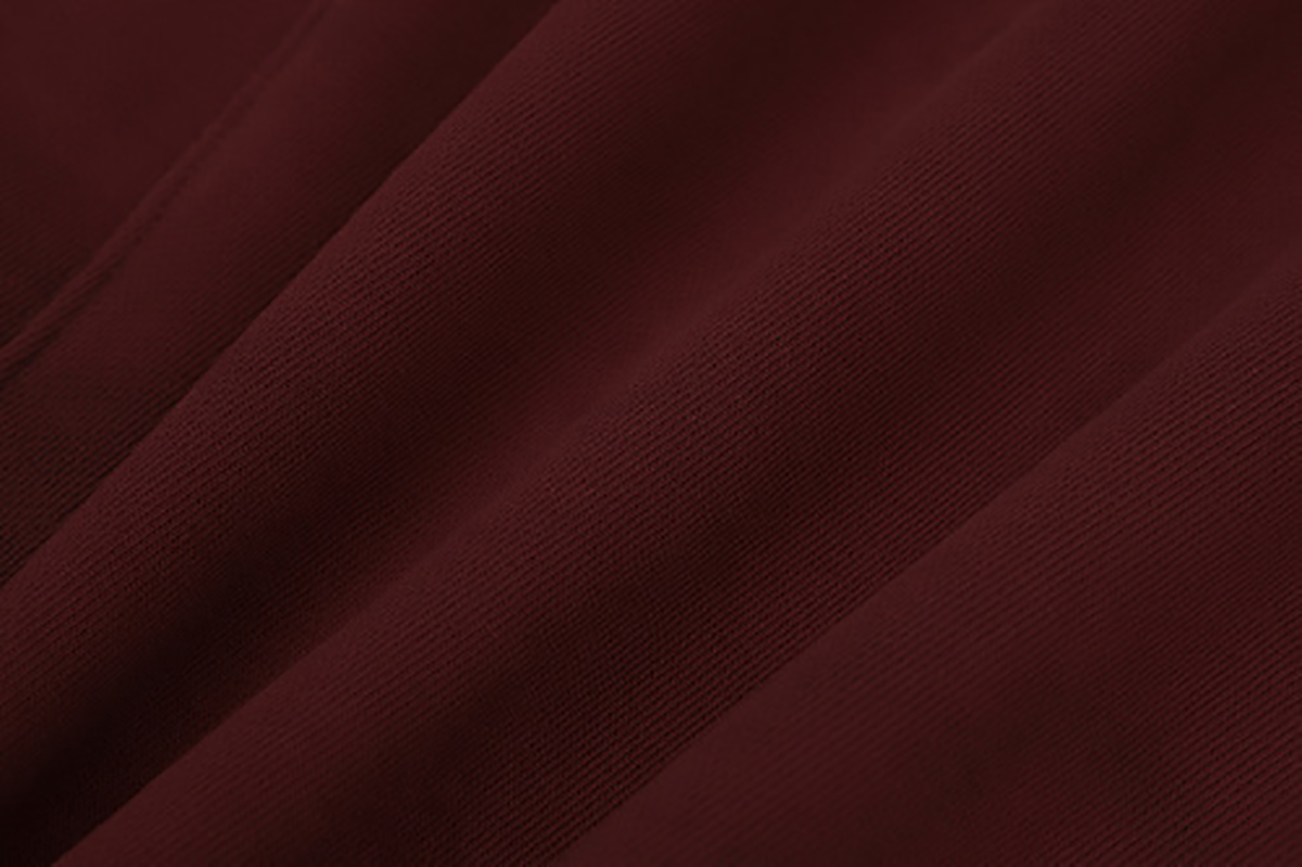 Close-up of burgundy hooded zip-up sweatshirt showing fabric texture and drape detail