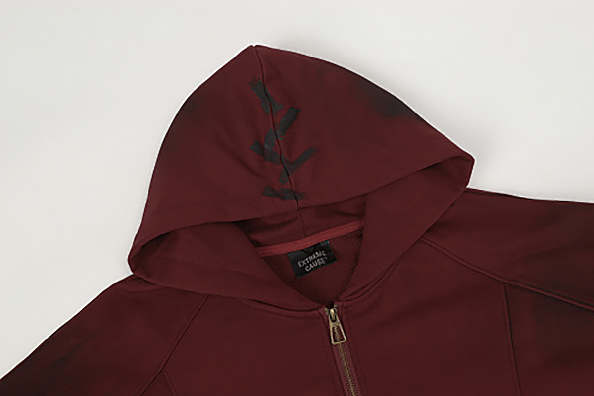 Close-up of burgundy hooded zip-up sweatshirt showing hood embroidery and front zipper detail