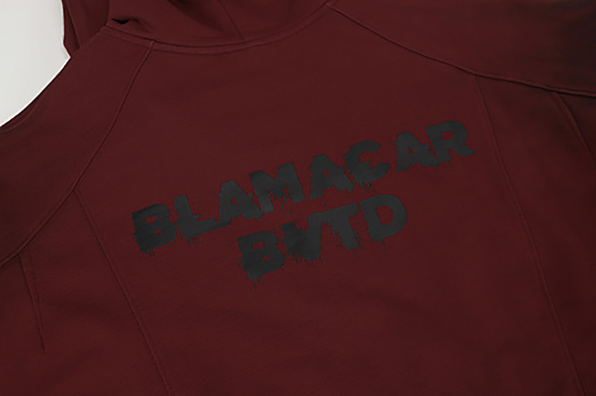 Close-up of burgundy hooded zip-up sweatshirt showing back letter print detail
