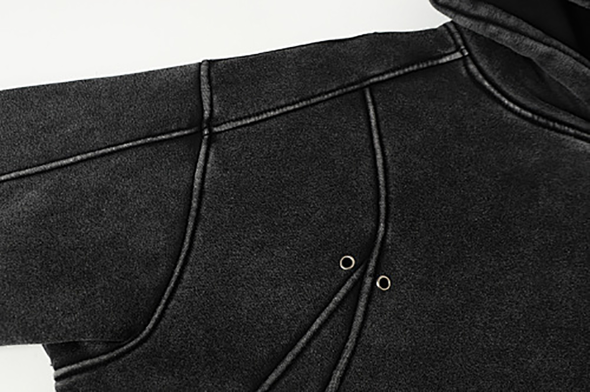 Close-up of men's black American heavyweight vintage deconstructed patchwork fleece-lined hoodie, showing shoulder and pocket patchwork detail