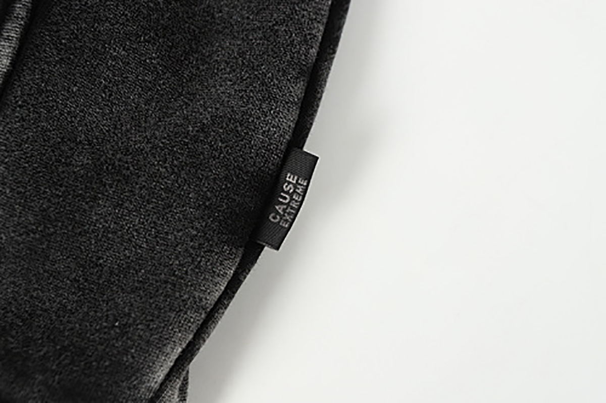 Close-up of men's black American heavyweight vintage deconstructed patchwork fleece-lined hoodie, showing outer brand tag detail