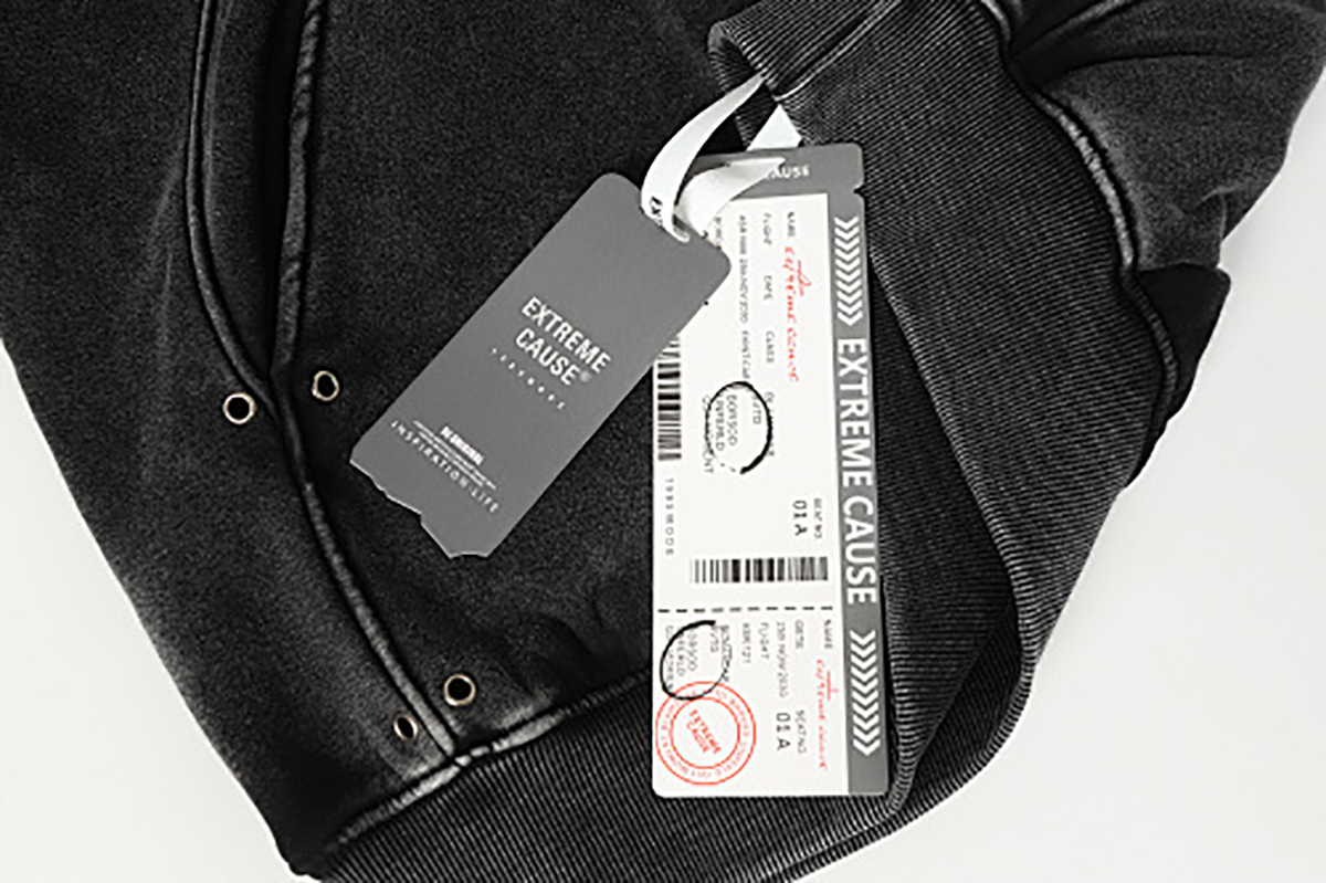 Close-up of men's black American heavyweight vintage deconstructed patchwork fleece-lined hoodie, showing hang tag and outer label detail
