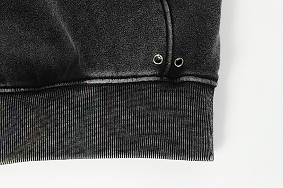 Close-up of men's black American heavyweight vintage deconstructed patchwork fleece-lined hoodie, showing hem detail