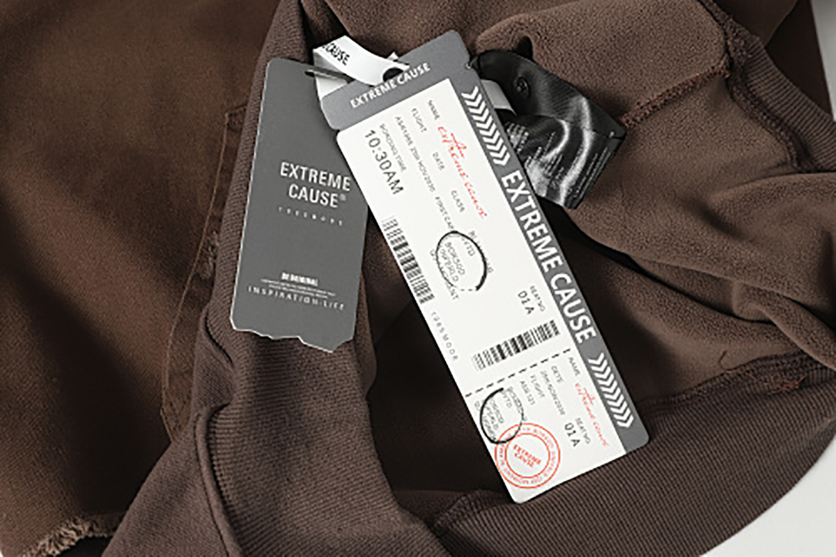 Close-up of men's coffee brown American retro patchwork hooded sweatshirt, showing hang tag and label detail
