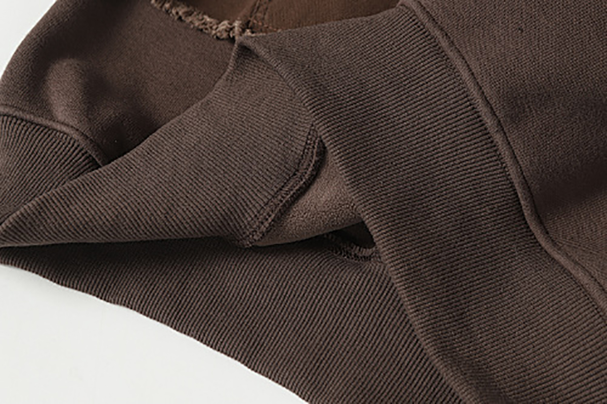 Close-up of men's coffee brown American retro patchwork hooded sweatshirt, showing fabric and stitching detail