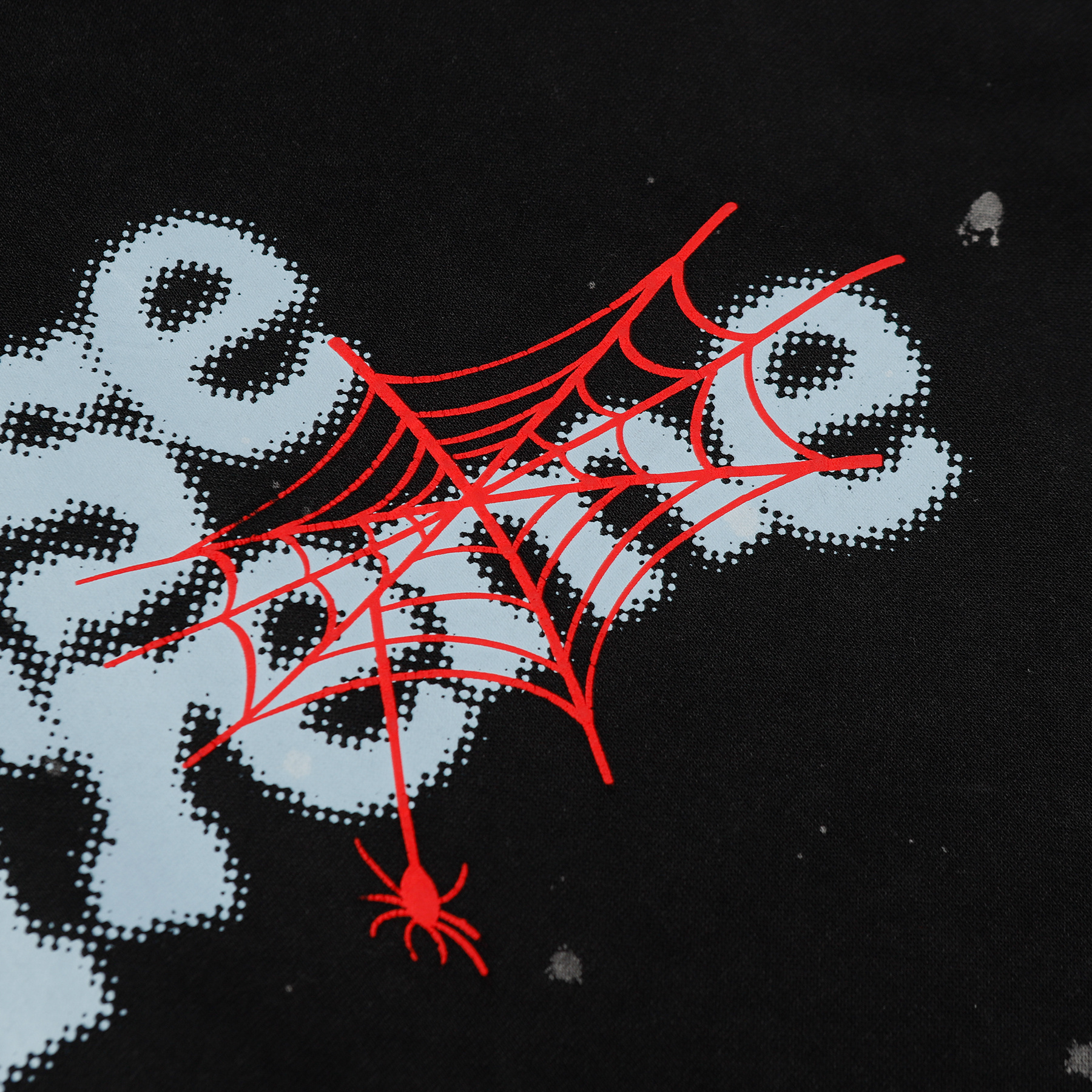 Close-up of 3D spider web puff print on black hoodie, showing "CAUSE EXTREME" lettering and red spider graphic