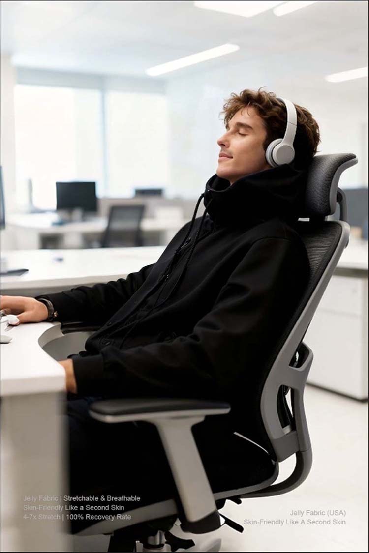 Man wearing black inflatable hoodie working in office, listening to music with headphones, casual work style